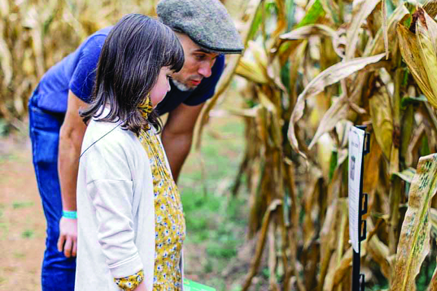 Father and daughter read a sign inside Liberty Mills Farm's corn maze