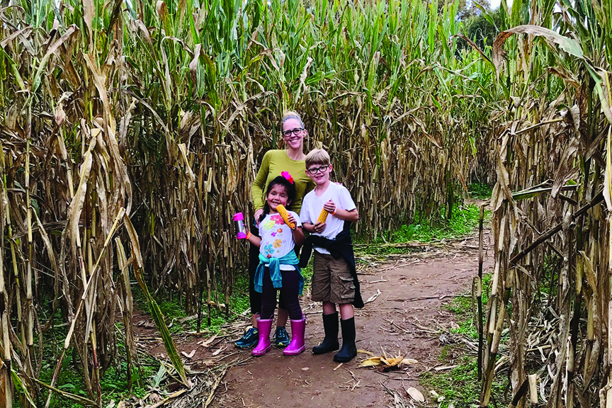 Mother and two children explore corn maze