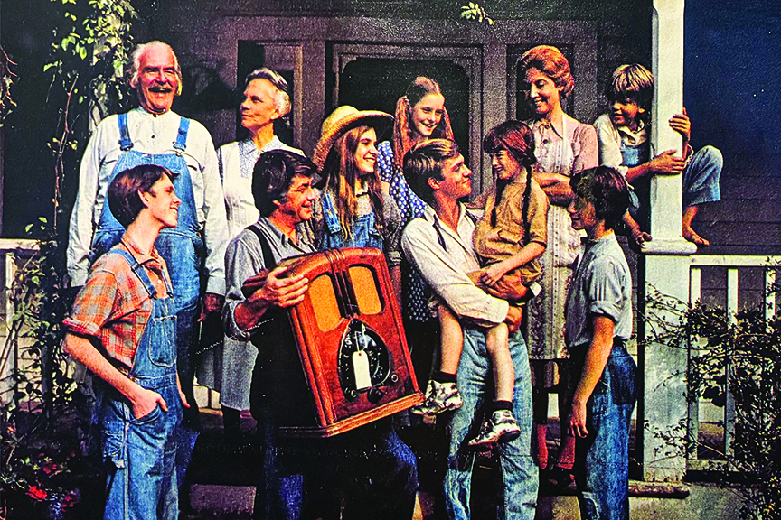 The full cast of "The Waltons" stands on the porch with a big radio