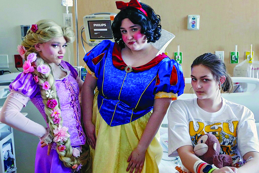 Rapunzel and Snow White poses with a teenage hospital patient