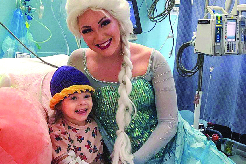 Woman dressed as ice queen poses with child in hospital