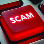 A bright red keyboard button reads "Scam"