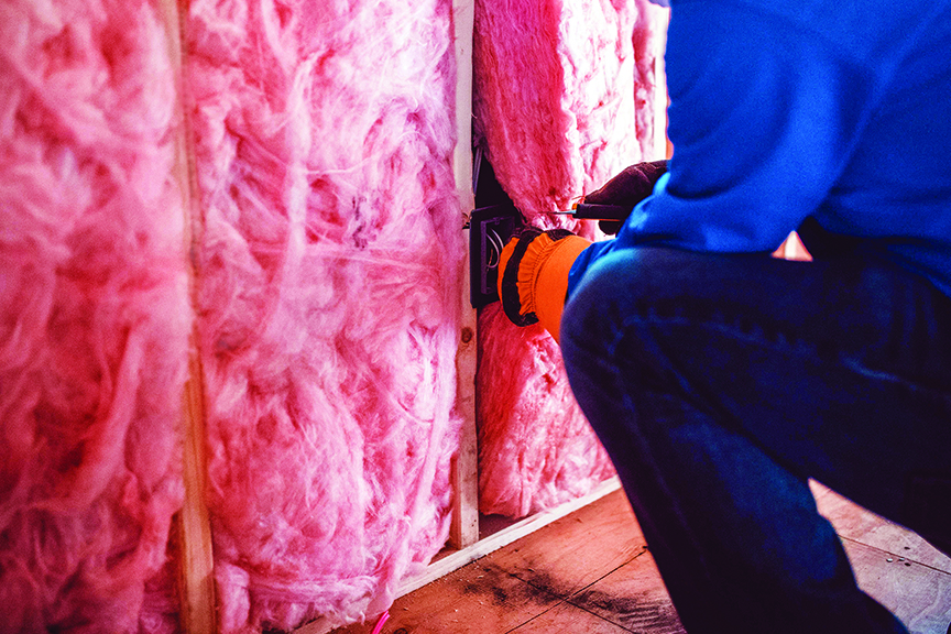 Worker installs insulation in a home