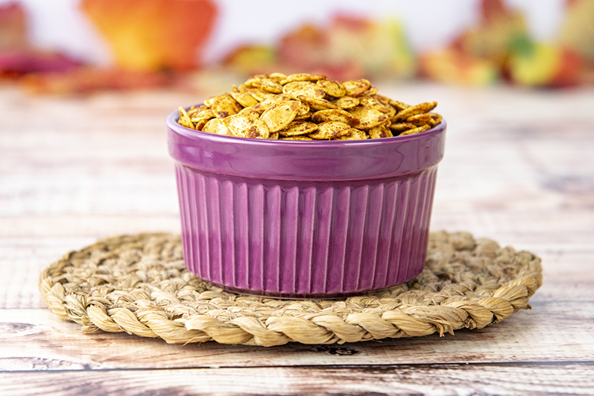 small purple dish holds roasted pumpkin seeds