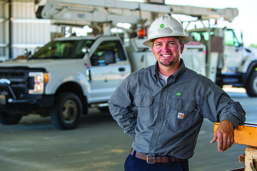 Lineman poses for a photo after a work day.