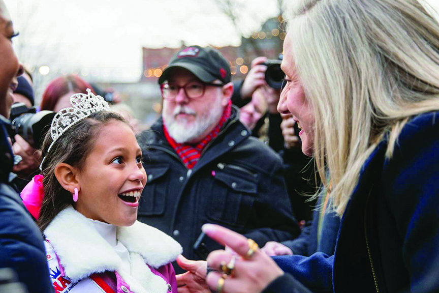 Abigail Spanberger talks to young pageant winner at a community event.