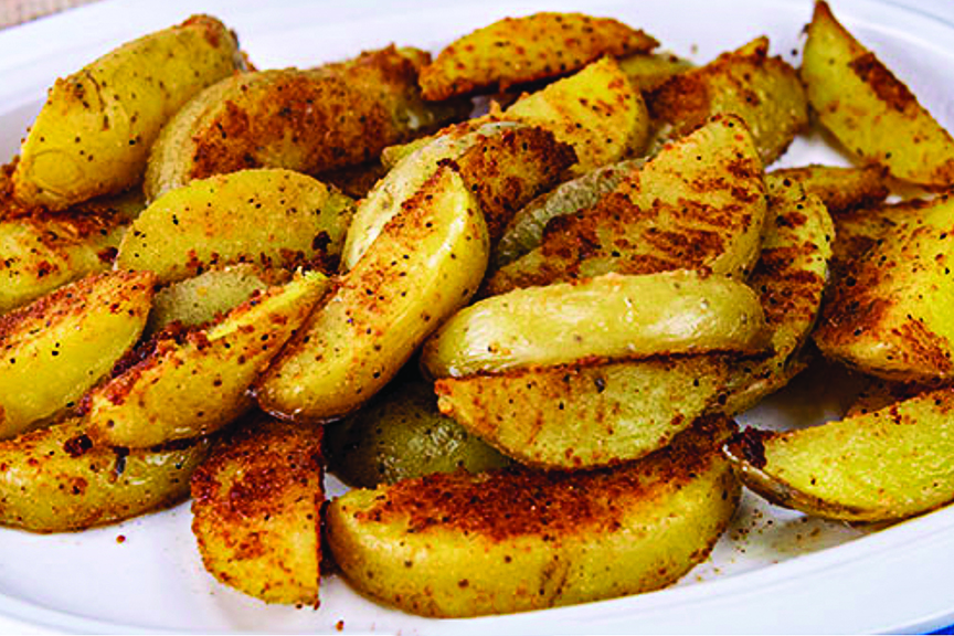 seasoned potato wedges in a white dish