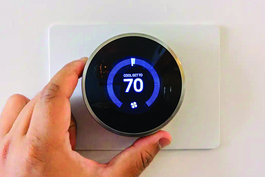 hand adjusting thermostat temperature to 70