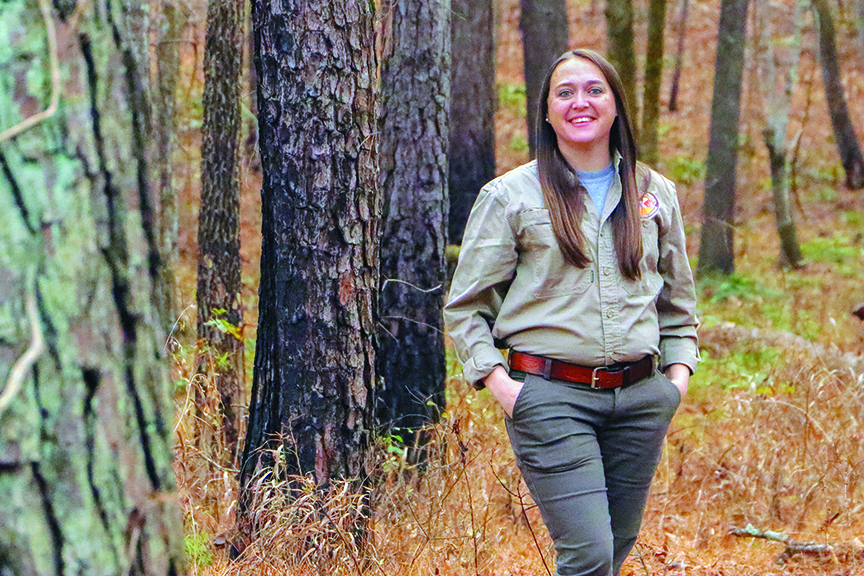 Uniformed Laura Hudson poses for a portrait in the forest