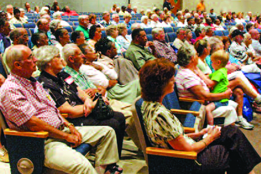 A seated crowd attends a meeting
