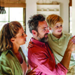 Mother, father and son look at home's smart thermostat