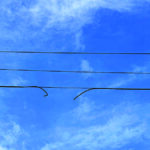 broken power line against blue sky