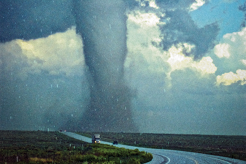 Image of rural highway shows funnel cloud in the distance