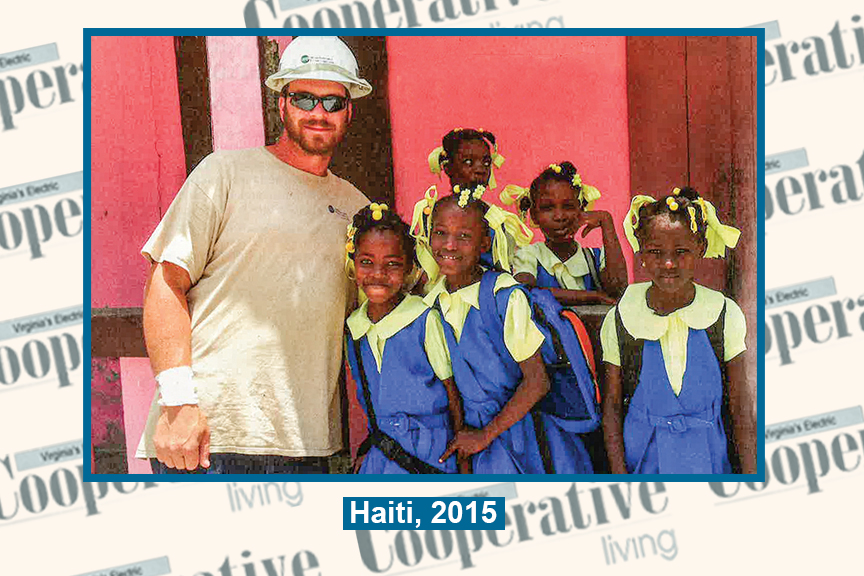 Lineworker poses with schoolchildren in Haiti in 2015