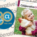 A cover of Cooperative Living magazine featuring a smiling young girl hugging a white hen, next to an 80th-anniversary logo (1946–2026).