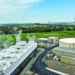 Aerial view of the Wildcat Point power generation facility in Cecil, Maryland, showing cooling towers with visible steam alongside surrounding buildings, storage tanks, and green rural fields.
