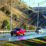 Two sedans travel on a Virginia Smart Road as it simulates rain.