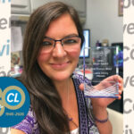 Photo of Laura Emery holding award on top of background showing repeated Cooperative Living logos and one round blue logo that reads "80th: 1946-2026"