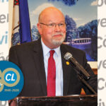 Richard Johnstone Jr. smiles as he speaks at podium