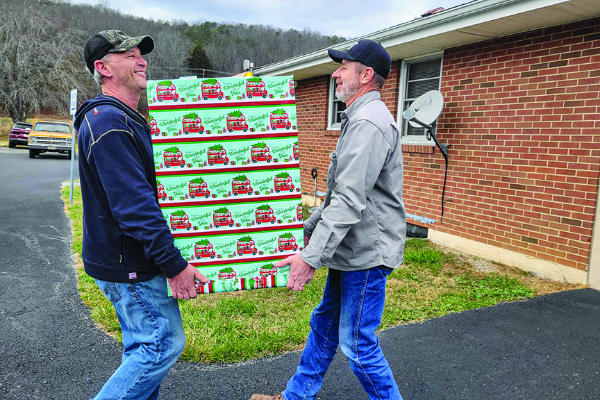 Two men carry large box of donations